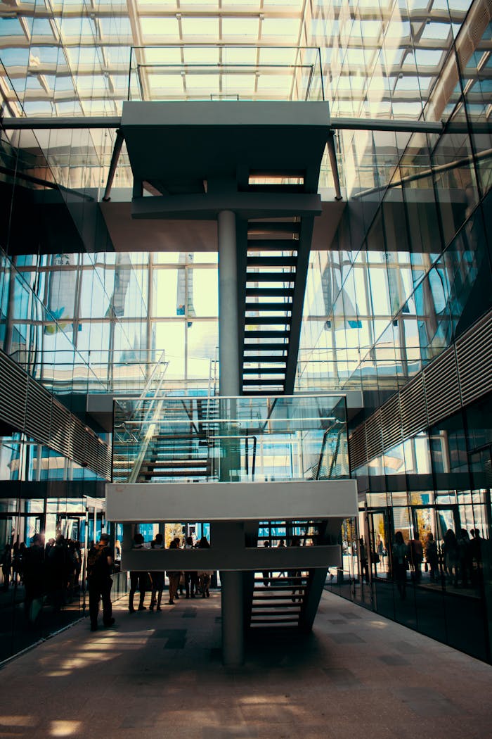 The Art of Drawing Readers In: Your attractive post title goes here Contemporary building interior with a striking glass facade and central staircase.
